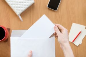 female-hands-holding-envelope-with-sheet-office-de_1163-2724