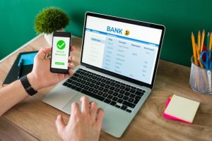 wire-transfer-young-man-using-his-smartphone-laptop-banking-transaction-some-payments_662251-2046