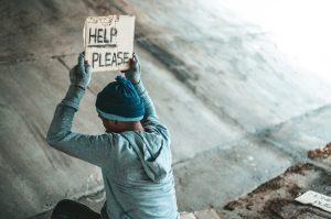 beggars-sitting-bridge-with-sign-help-please_1150-22956