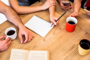 elevated-view-students-with-study-materials-cups-coffee-wooden-textured-table_23-2148192464