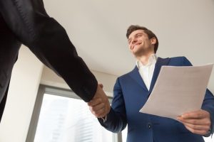 smiling-company-manager-welcoming-client-office_1163-5290