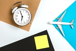 alarm-clock-paper-reminder-airplane-model-colored-paper-background_169016-33990