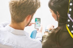 friends-using-application-mobile-phone-by-connecting-with-smart-watch_23-2147844551